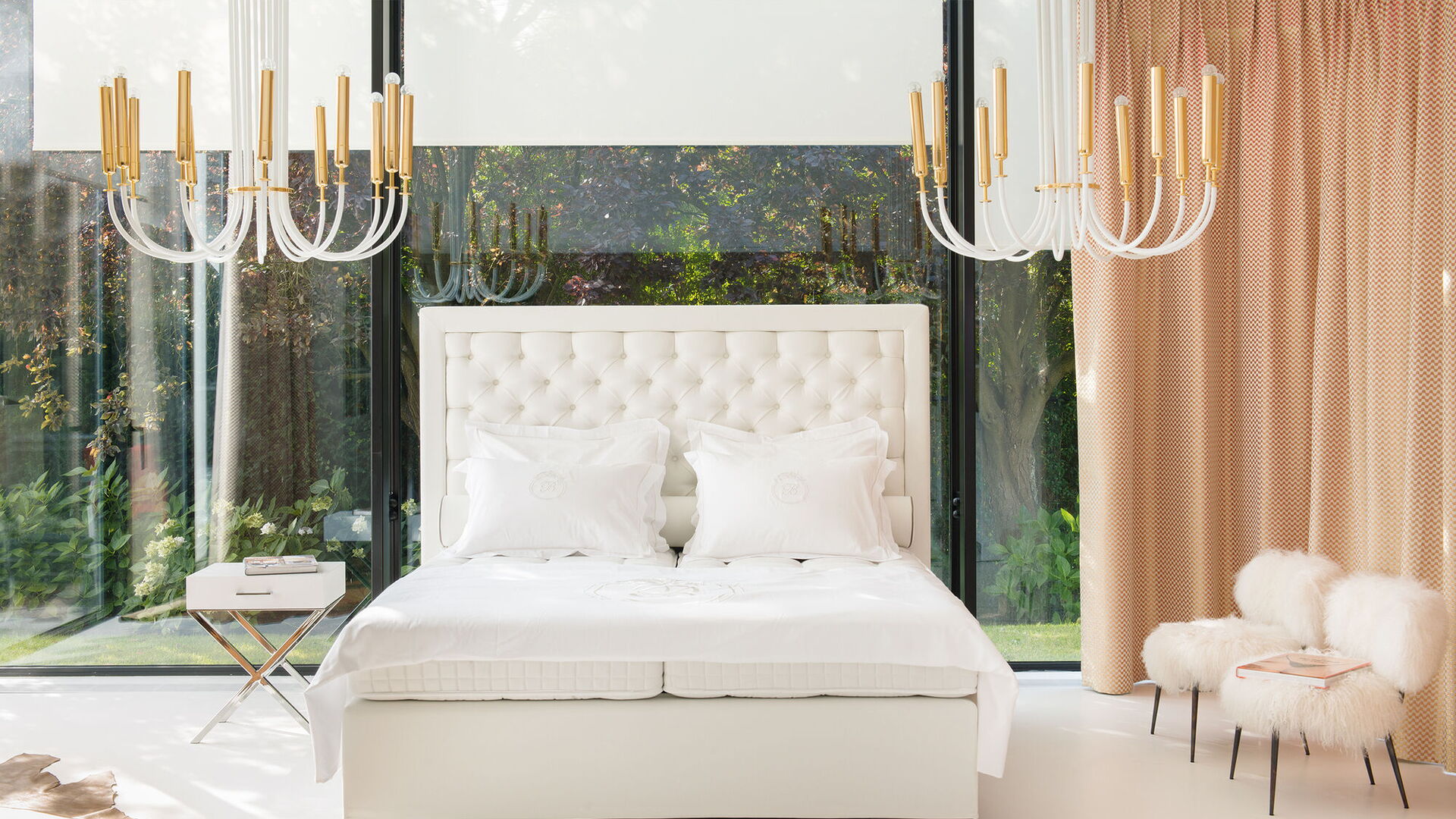 Weißes Boxspringbett mit hohem Kopfteil und Kronleuchter