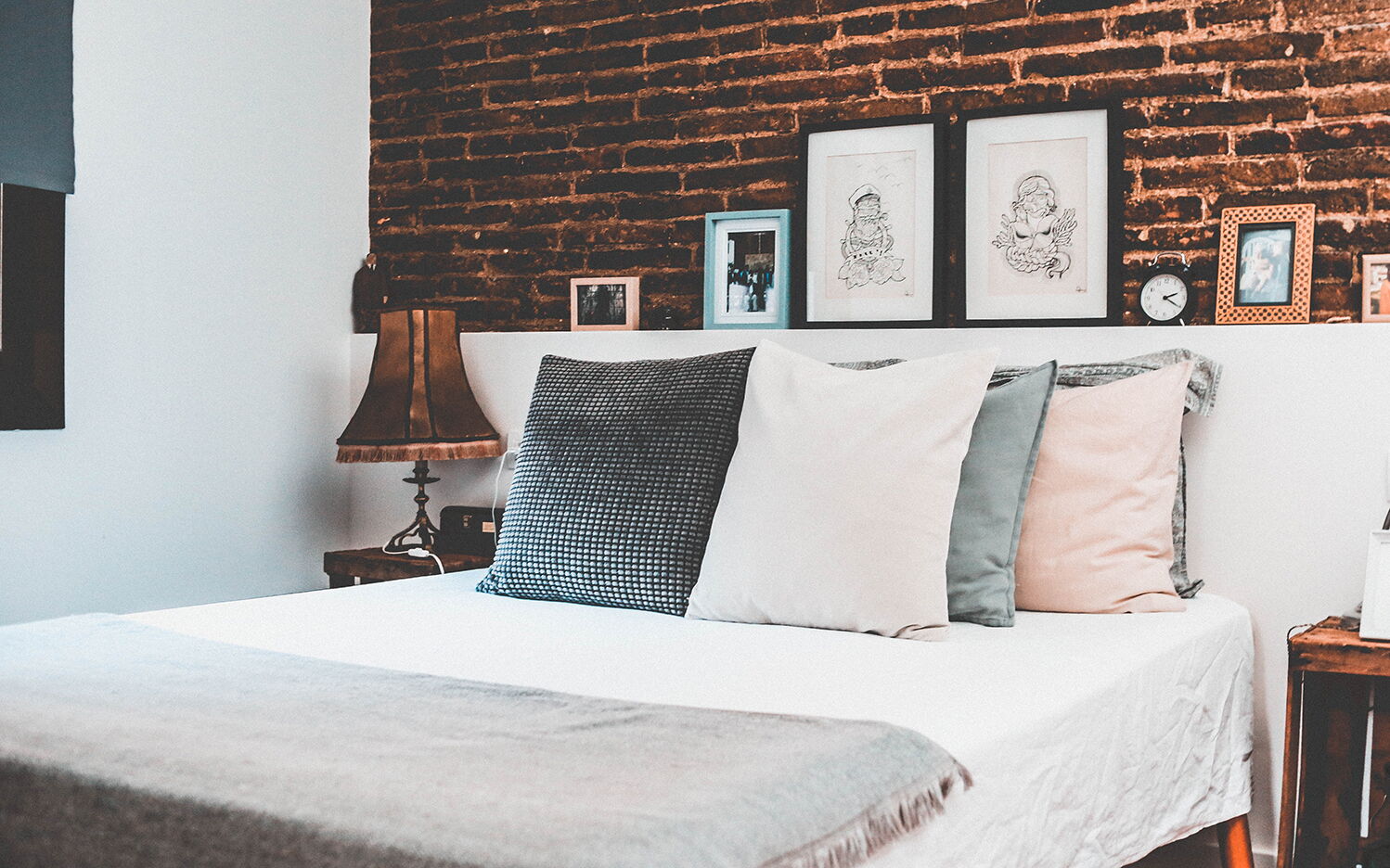 Frisch bezogenes Wasserbett mit weißer Wäsche vor einer Ziegelwand
