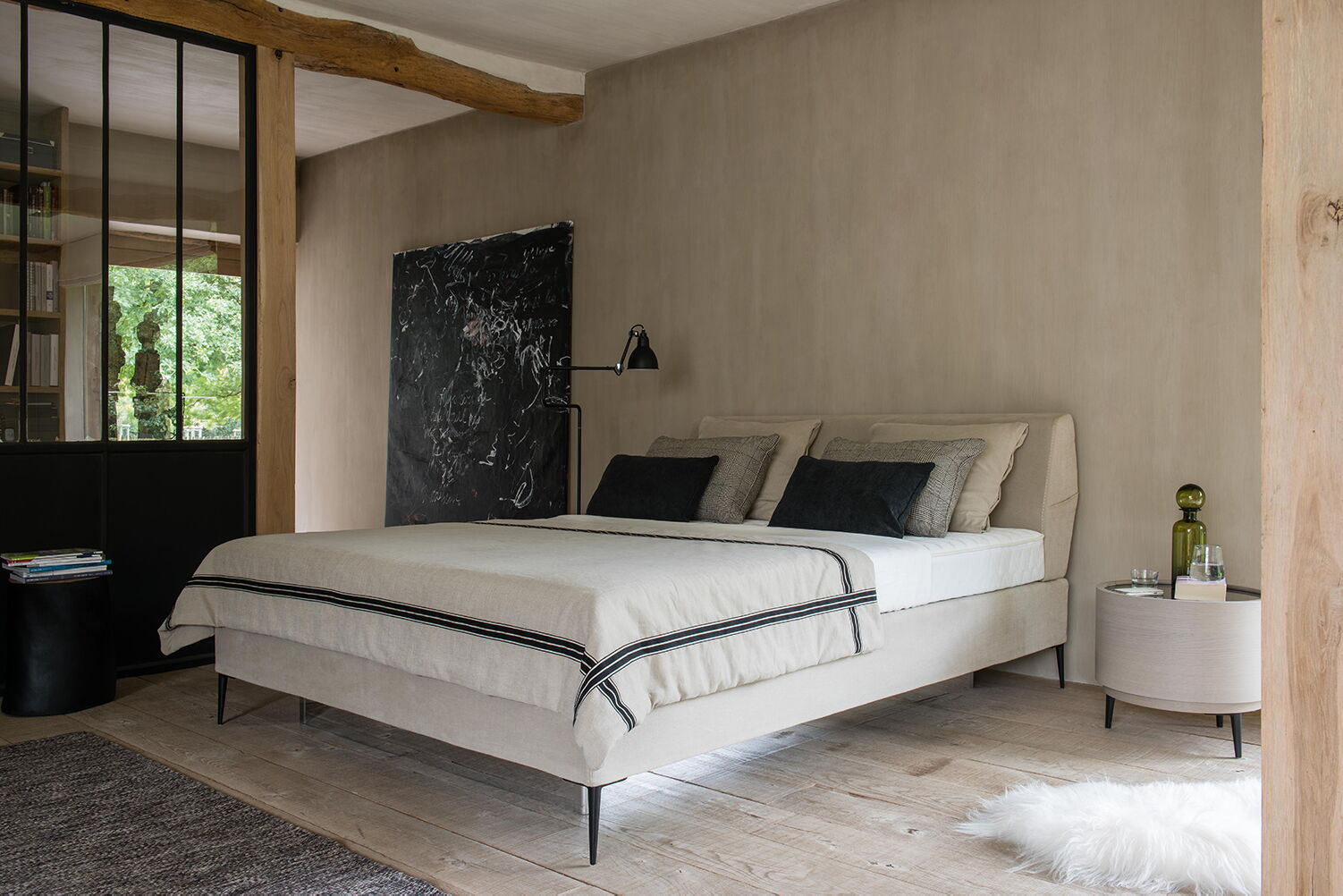 Wasserbett in Boxspring-Optik vor einer Ziegelwand