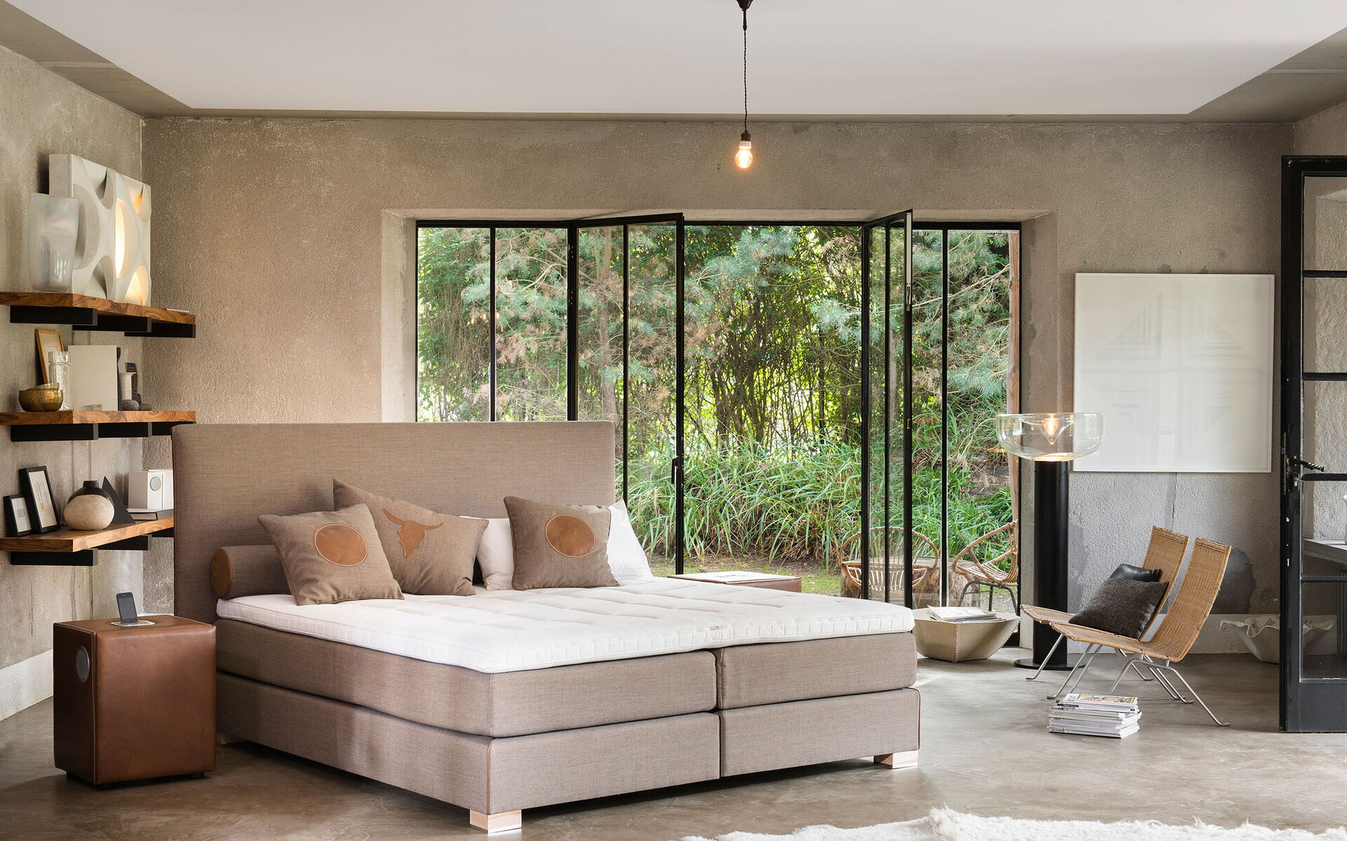 Boxspringbett in Beige in einem Raum mit Gartenblick