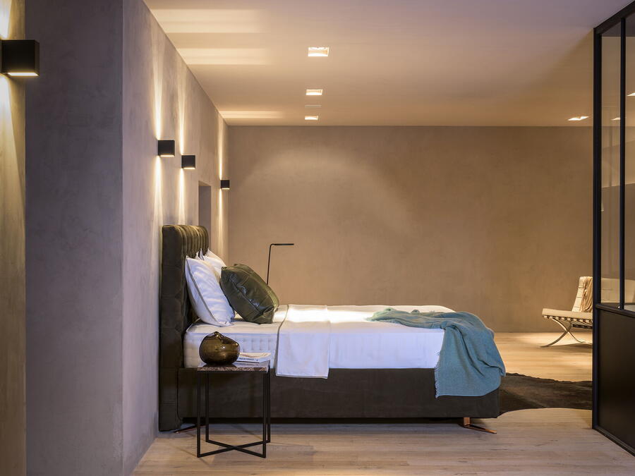 Boxspringbett mit gepolstertem Bettrahmen und Wandleuchten